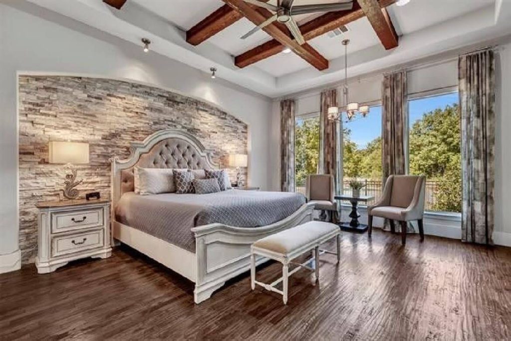 master bedroom with sitting area and ceiling beams
